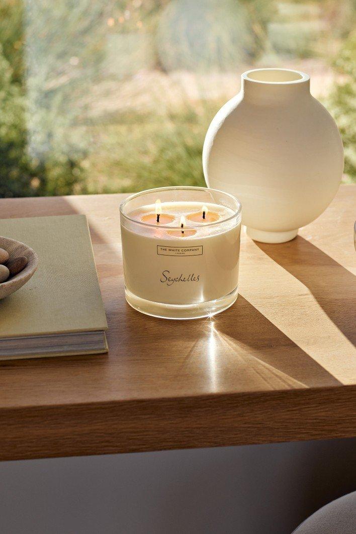 a candle sitting on a table next to a vase of flowers