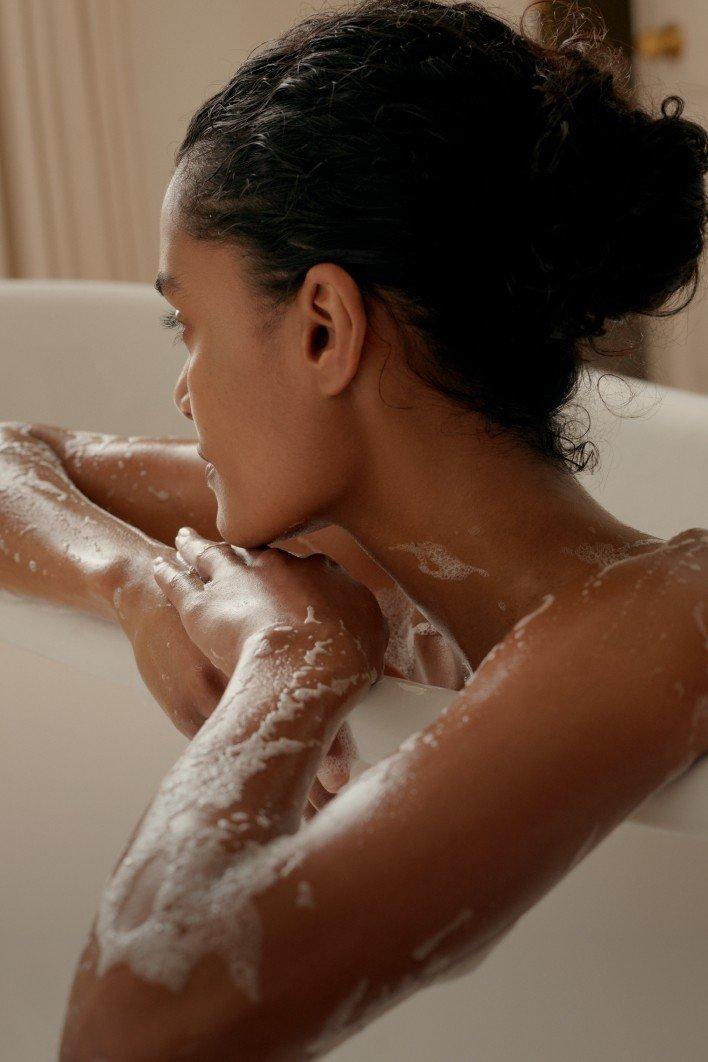 a woman in a bathtub with soap suds on her body