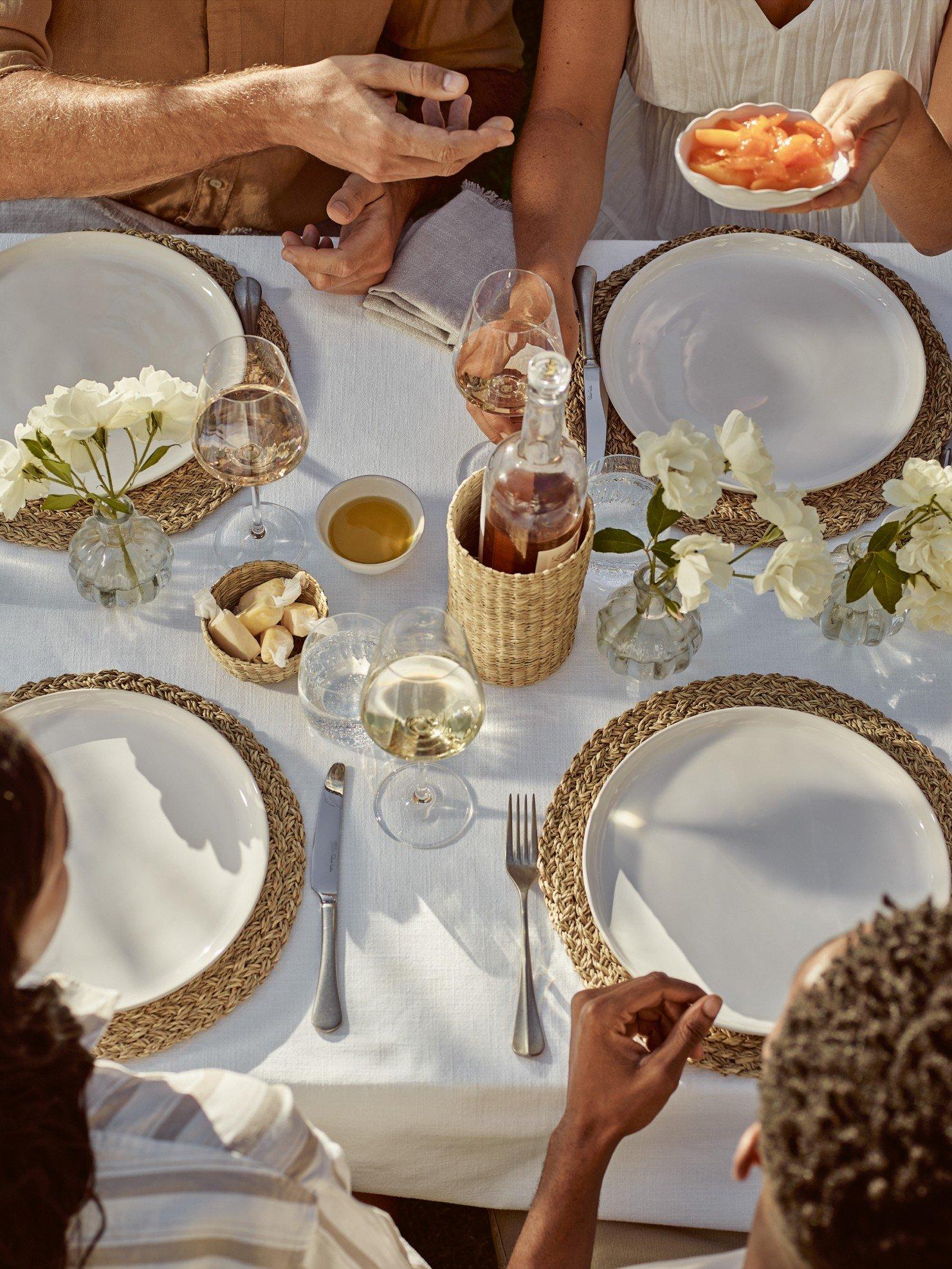 a group of people sitting around a table with plates of food