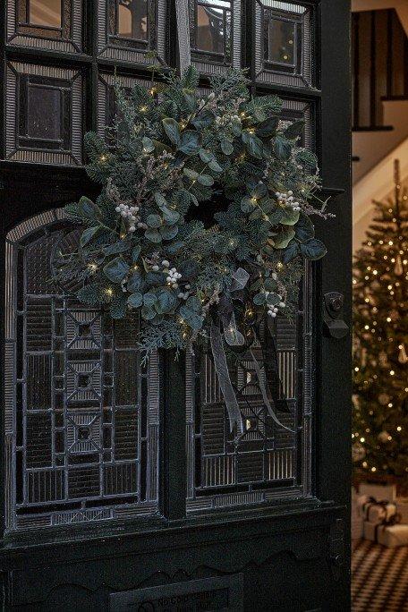 a wreath hangs on the front door of a house