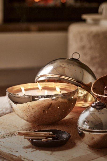 a table with a candle and a bowl of metal objects