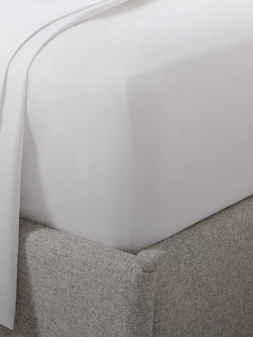 a close up of a bed with a white sheet on it