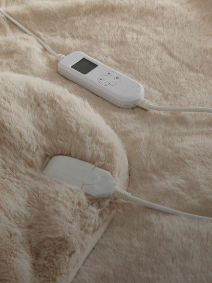 a remote control and a video game controller are plugged into a blanket