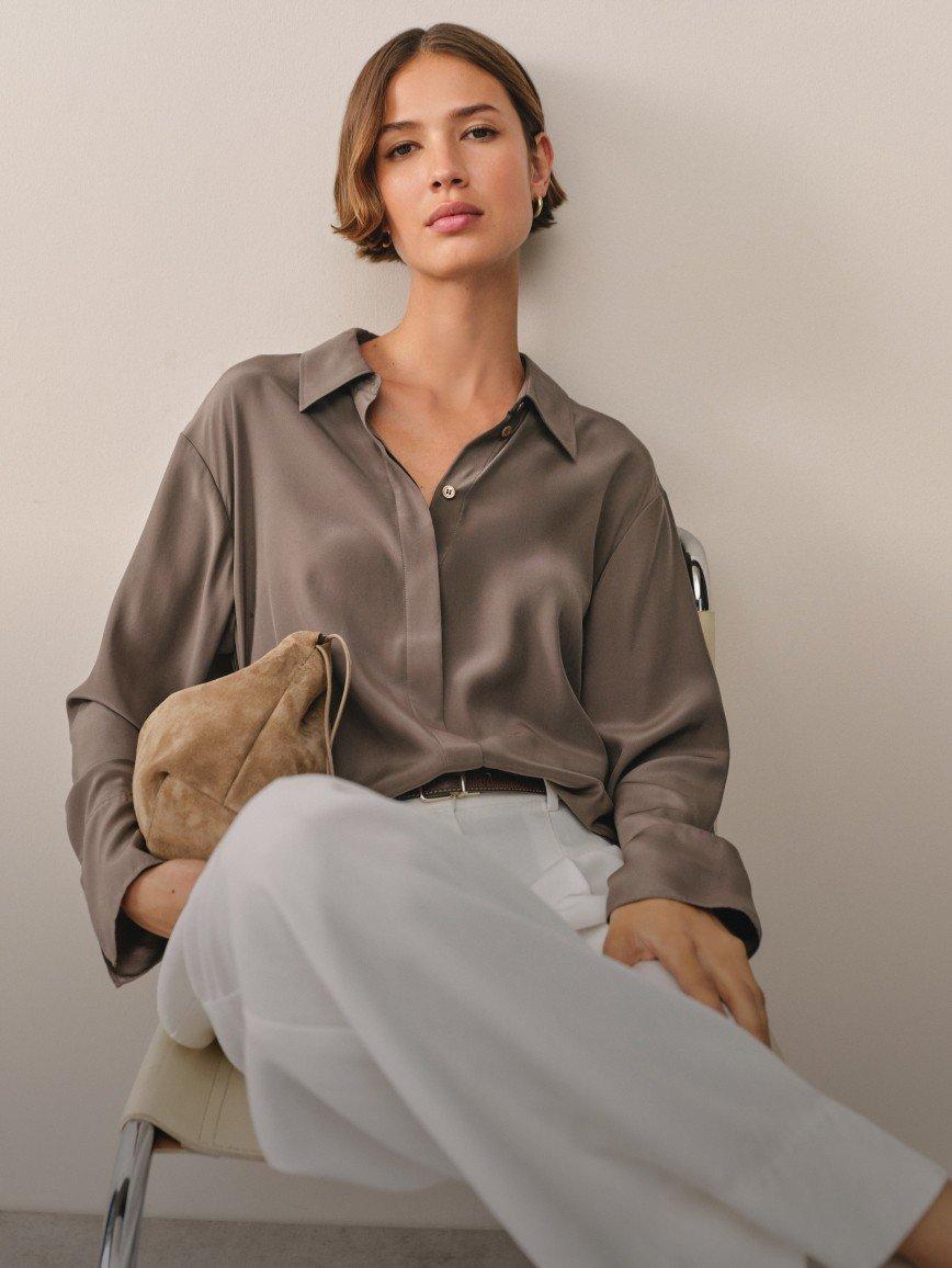 a woman sitting on a chair with a purse on her lap