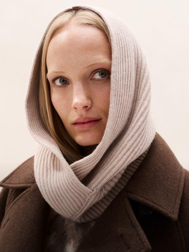 a woman wearing a scarf and a jacket with a hood