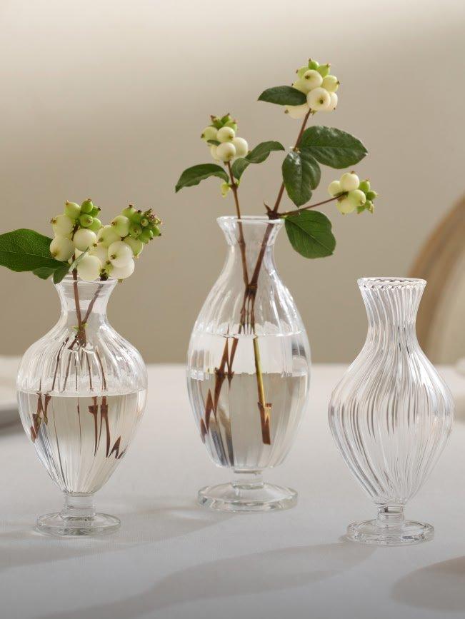 three clear vases with flowers in them on a table