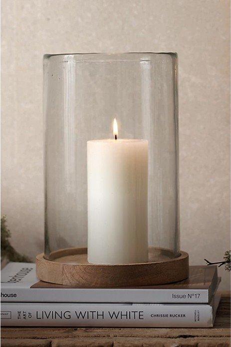 a candle sitting on top of a stack of books on a wooden table