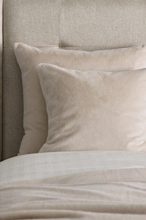 a close up of a white quilt on a bed with a white blanket