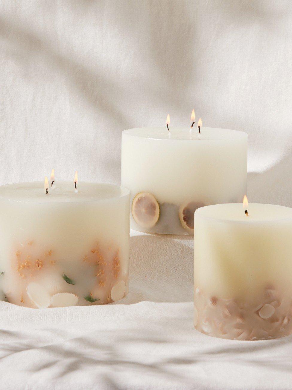 three candles with different designs and colors are sitting on a table