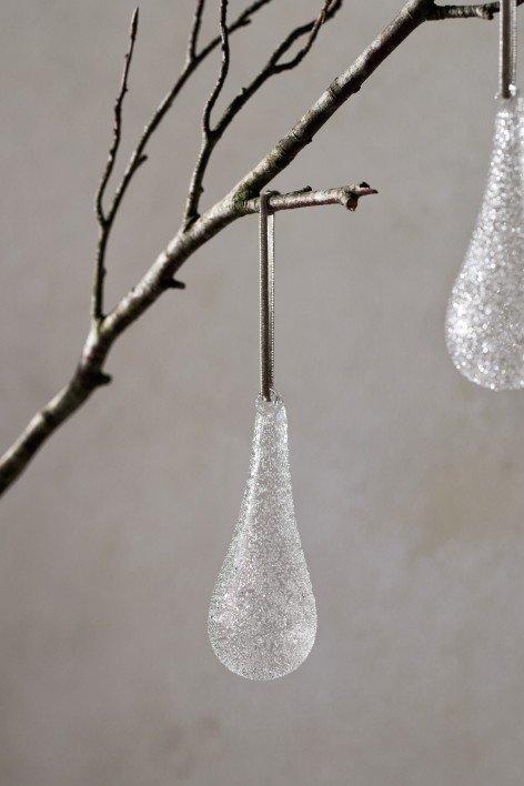 two silver star ornaments hanging from a christmas tree