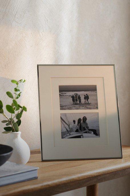 a picture of a picture frame on a table with a vase and a plant