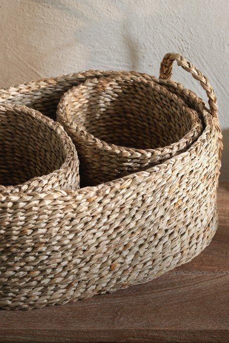 a basket with three small bowls sitting on a wooden table