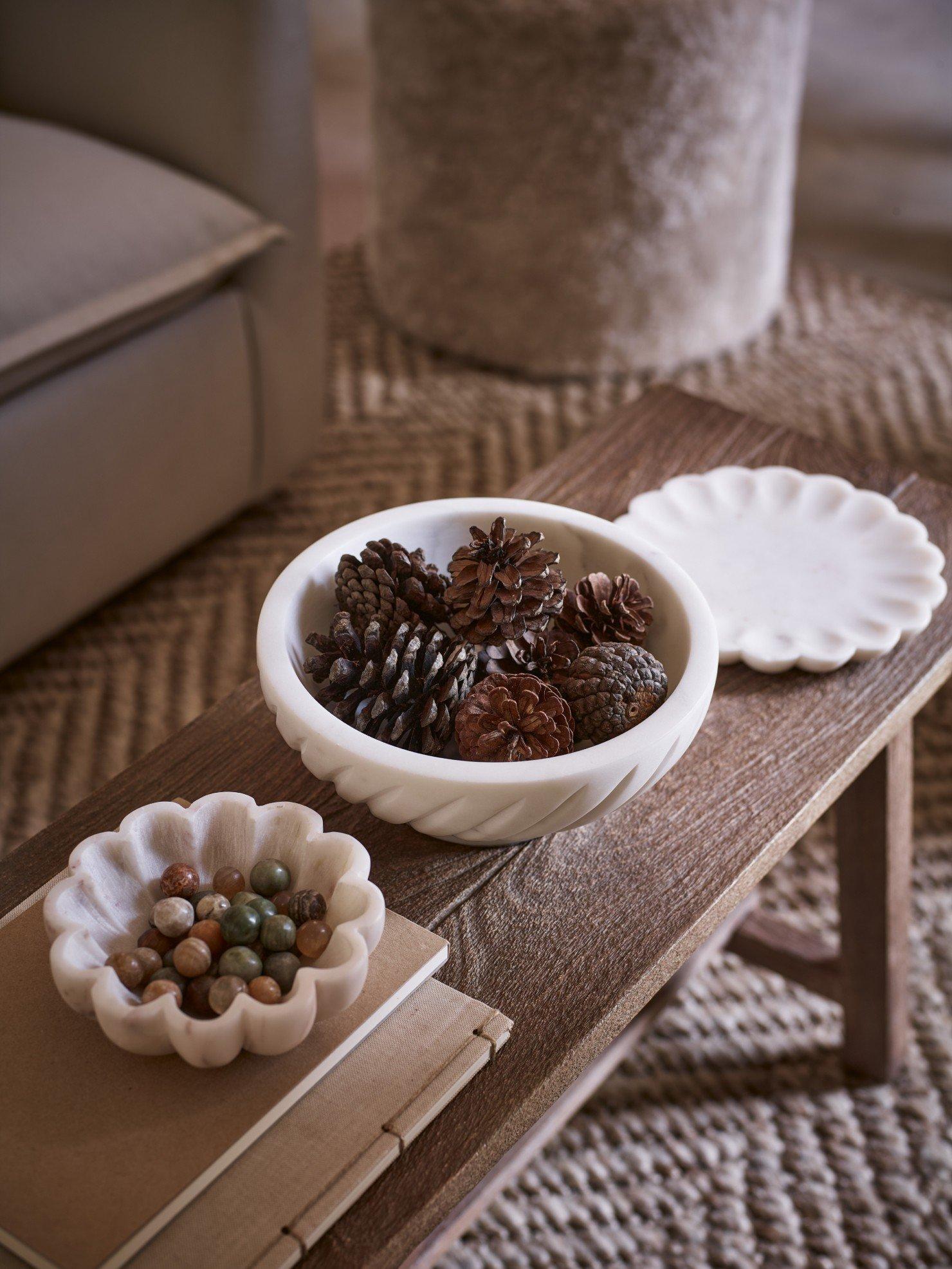 a table with a bowl of pine cones and a bowl of nuts