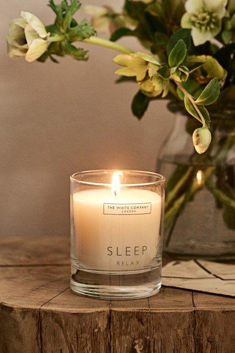 a candle sitting on a table next to a vase of flowers