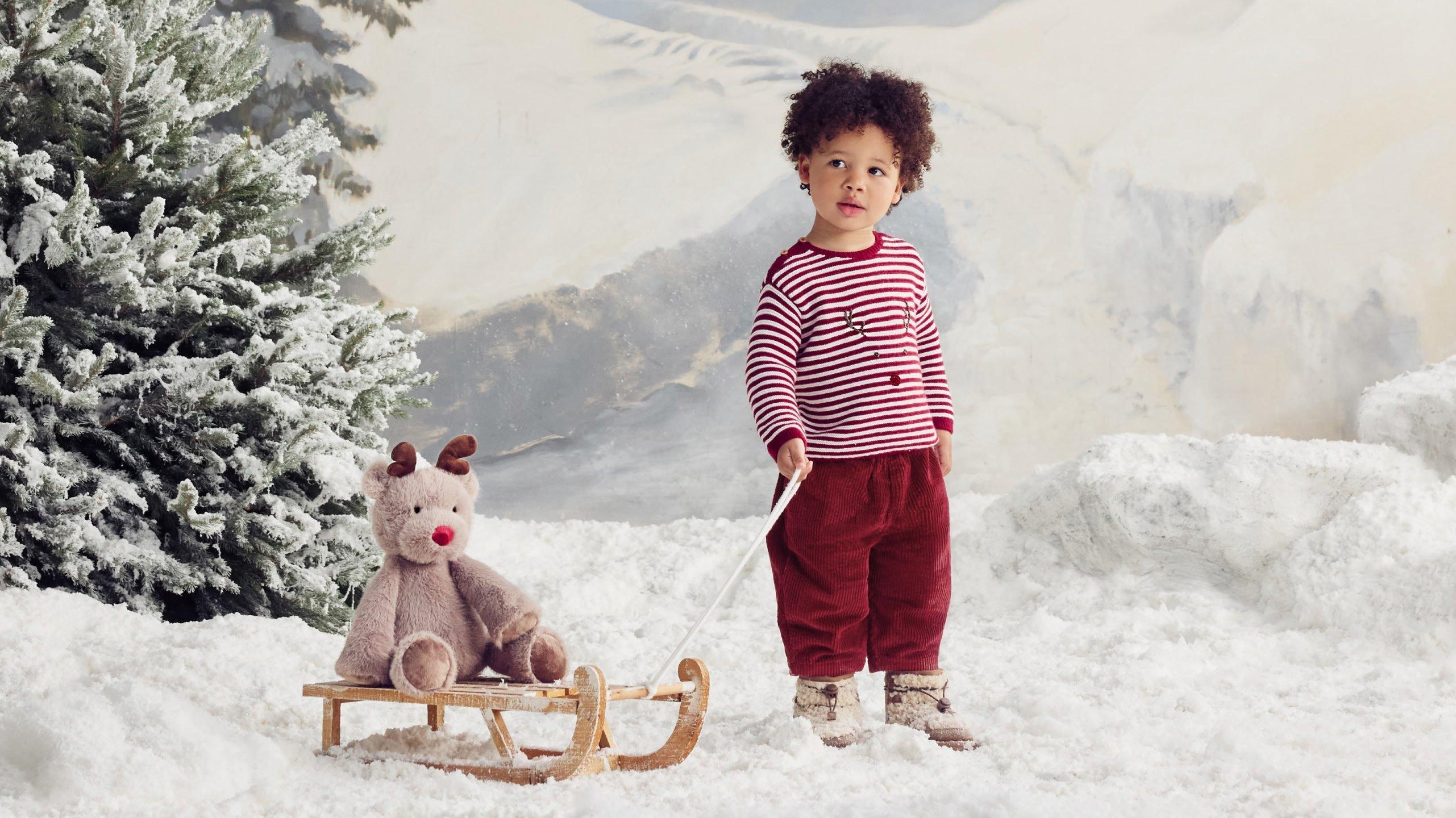 a child in jingles clothing and toy