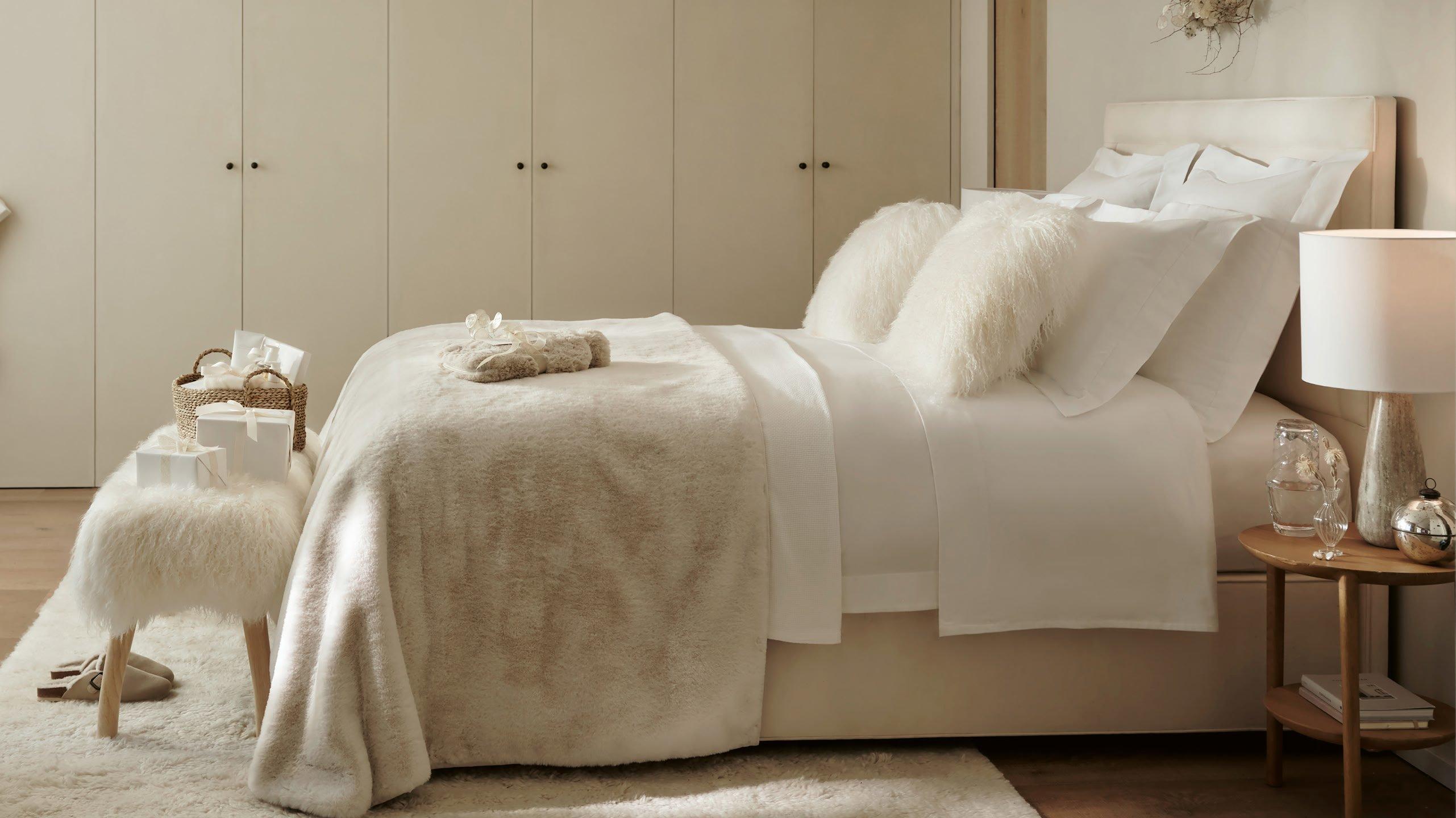 a bedroom with a bed, a table and a lamp