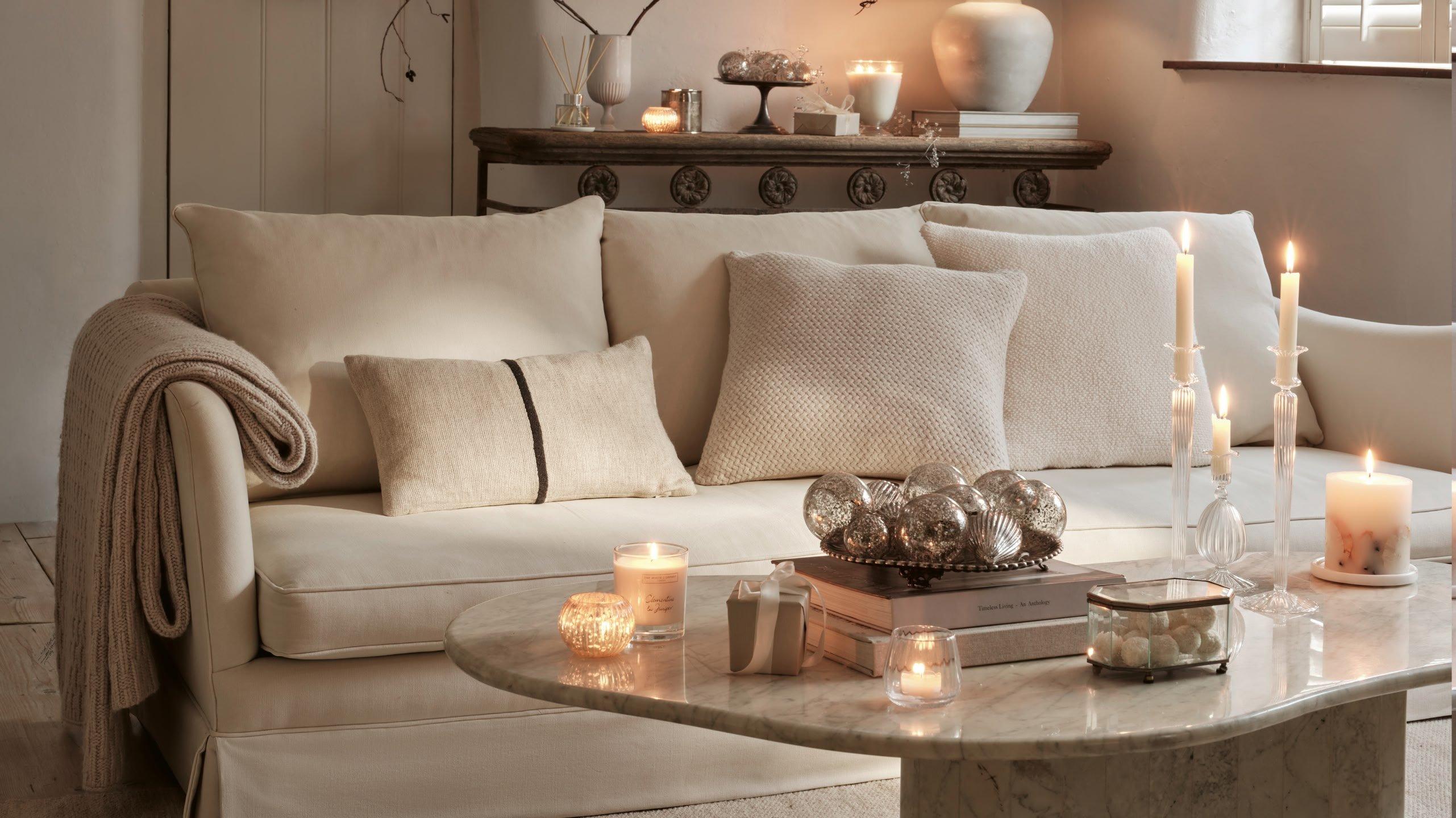 a living room with a couch, table and candles