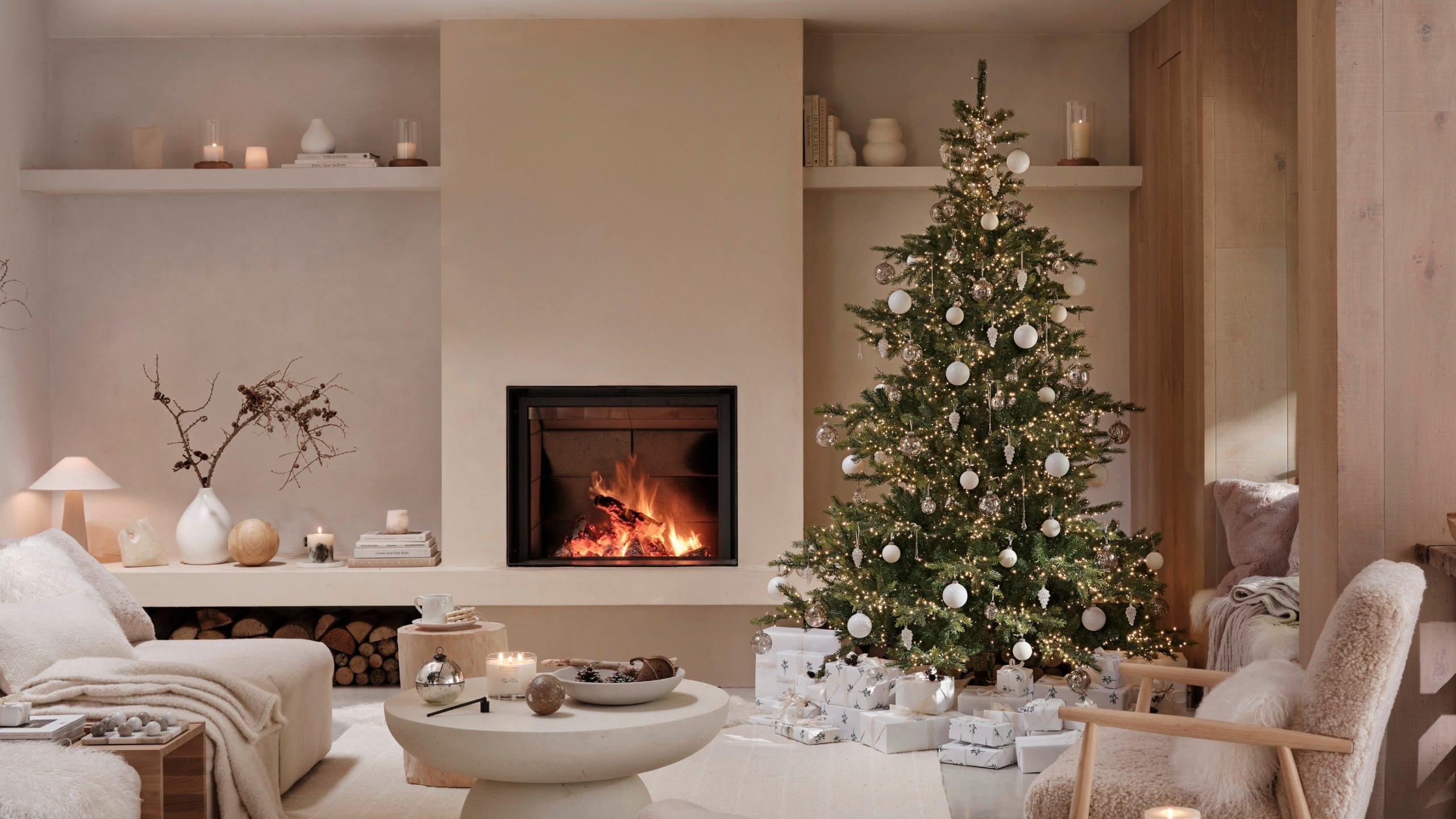 a living room with a fireplace and a christmas tree
