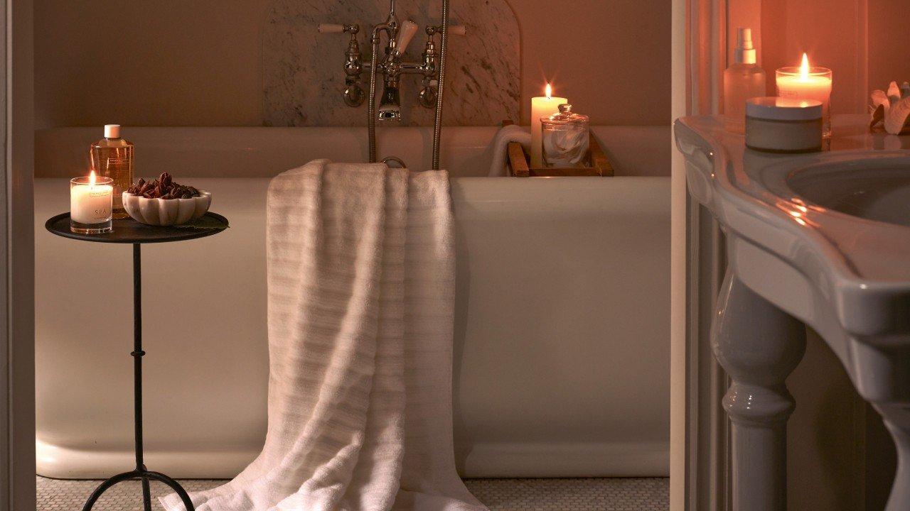 a bathroom with a bathtub and candles lit in the room