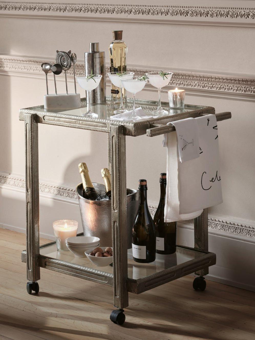 a bar cart with bottles of wine and champagne on it