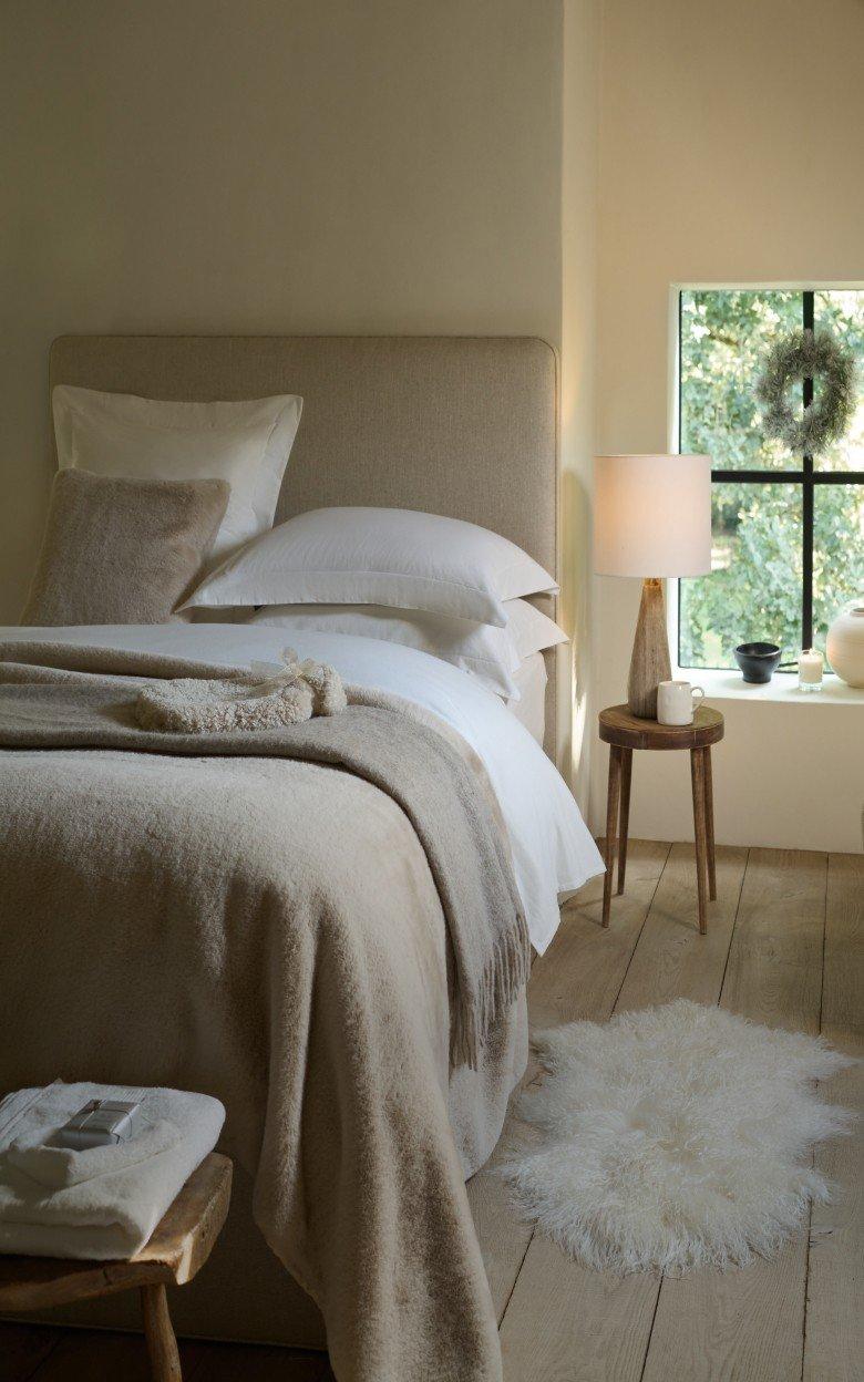 a bedroom with a bed, a window, a rug and a lamp