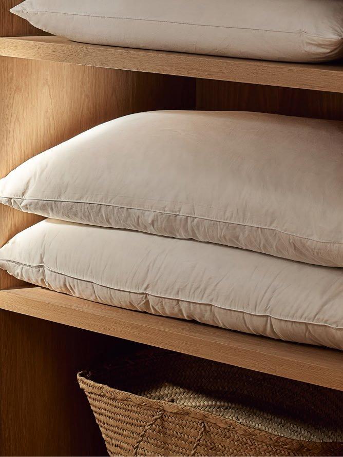 a shelf with pillows and a basket on it in a room