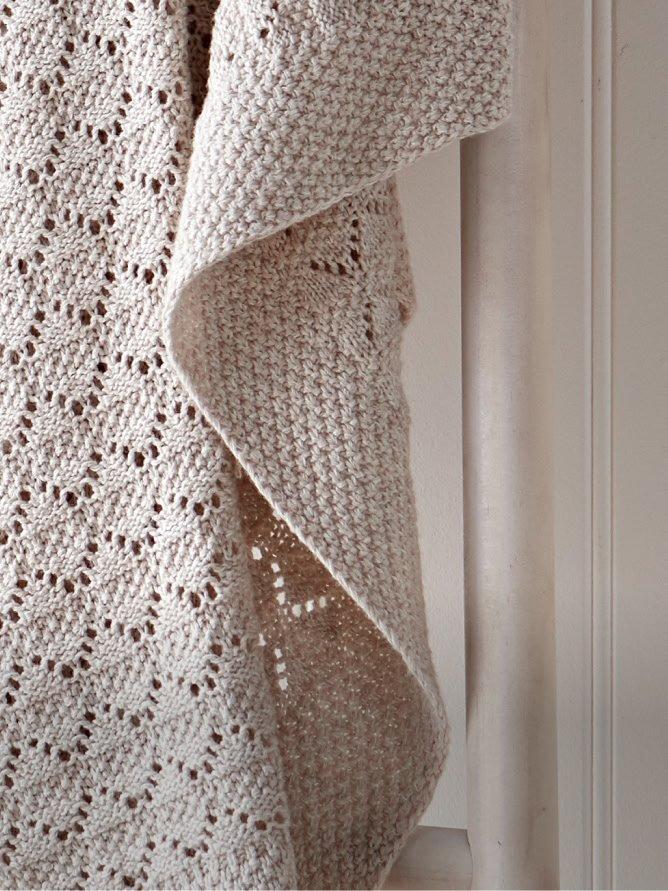 a close up of a white blanket hanging on a chair