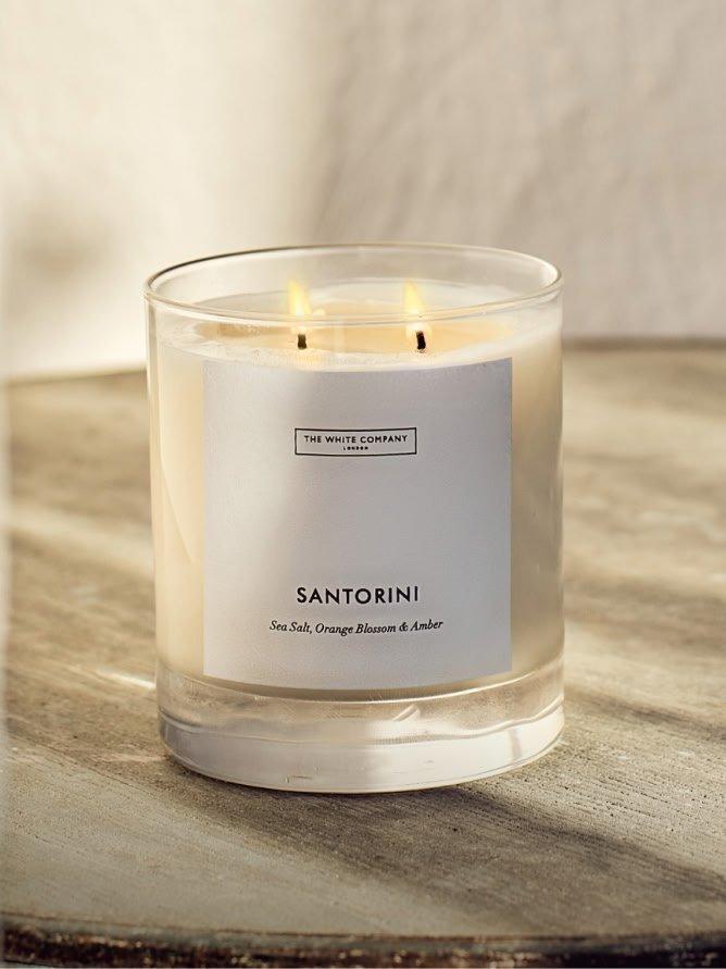a candle sitting on a table with a glass next to it
