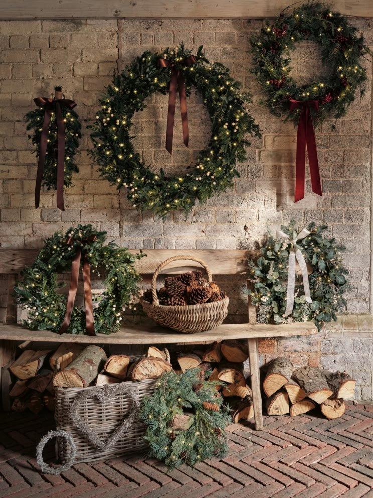 a bench with wreaths and logs on it in front of a brick wall