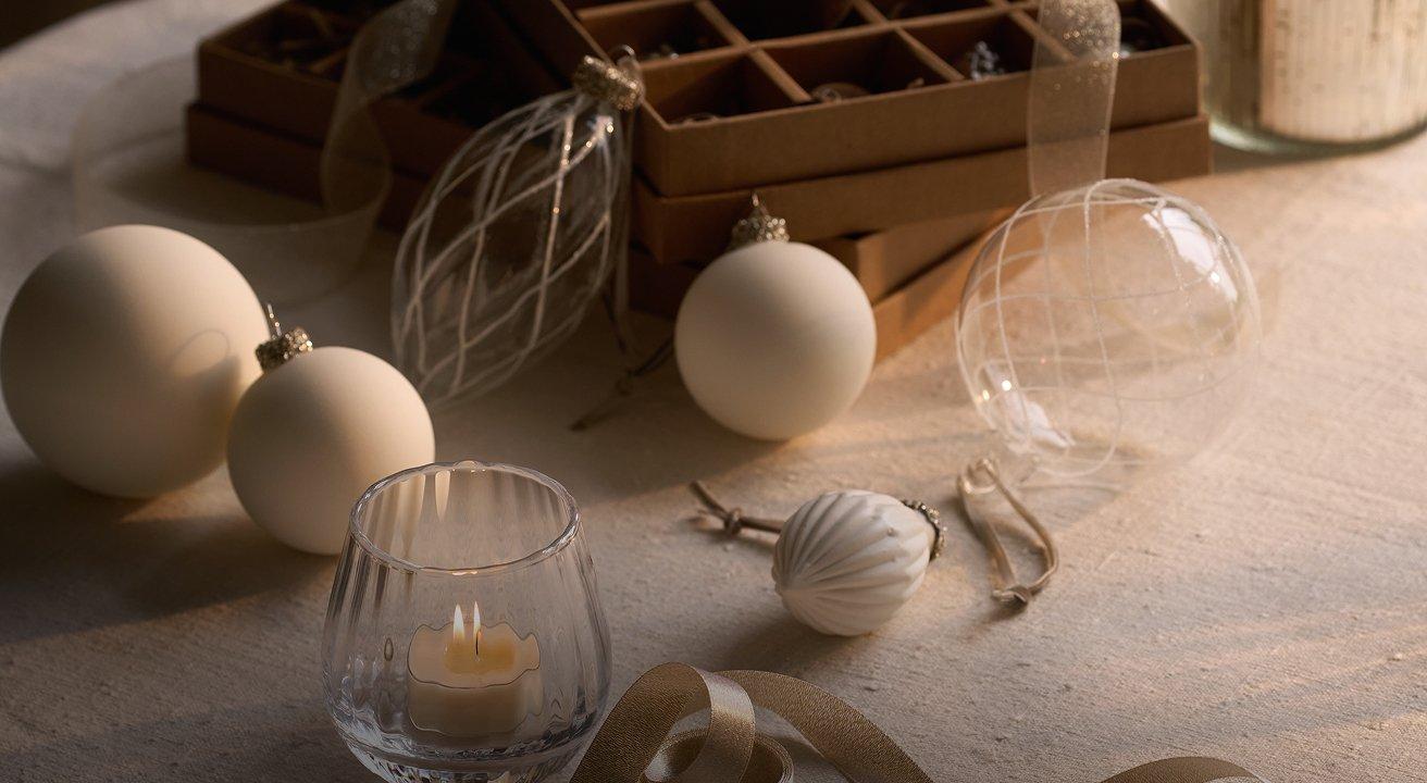 a table with a candle, ornaments and a box of ornaments