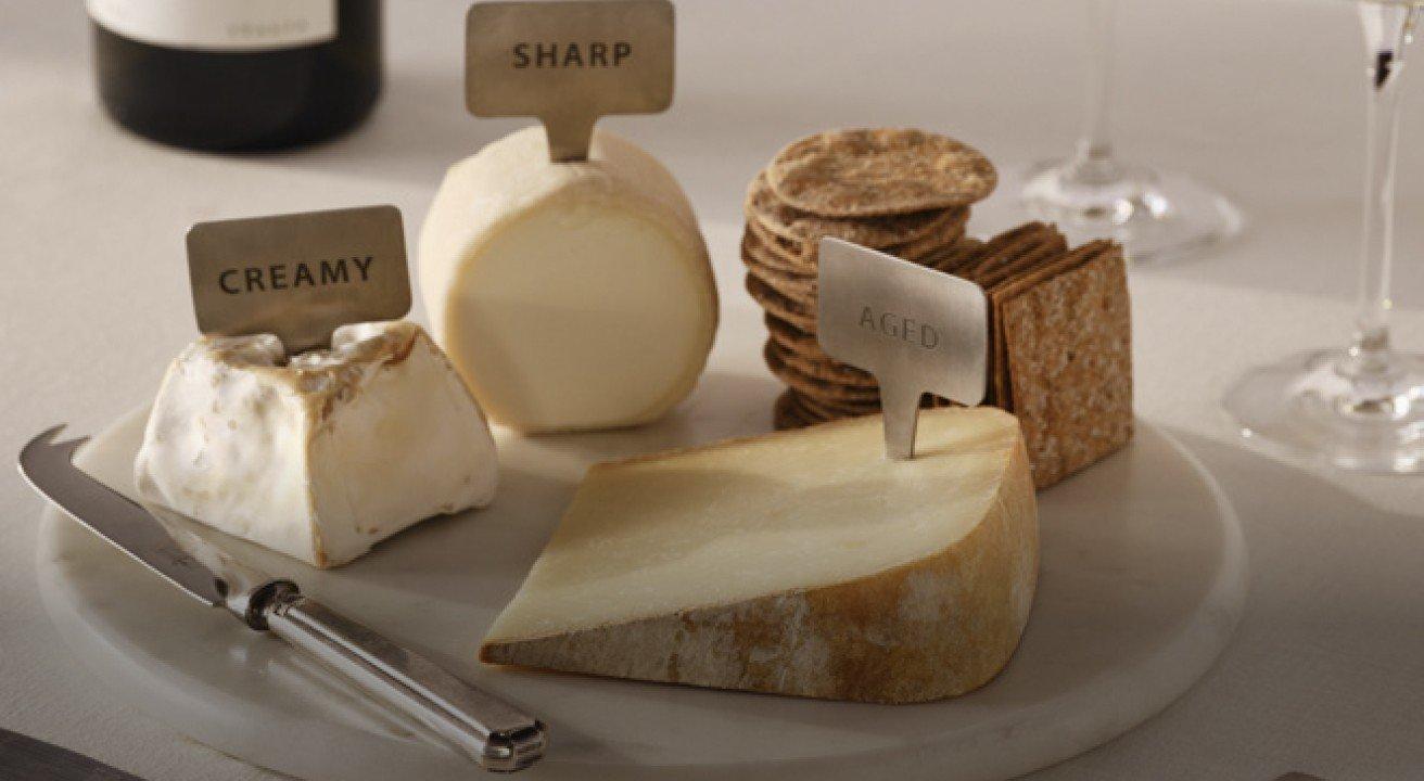 a plate of cheese and crackers on a table with a bottle of wine