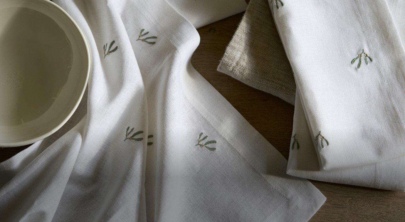 a white bowl sitting on top of a table with a white cloth